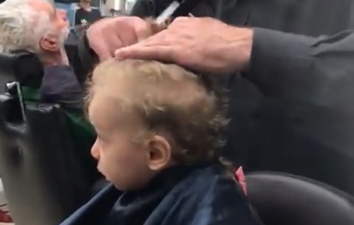 Chez un barbier, ils se mettent tous  chanter pour consoler ce petit garon apeur